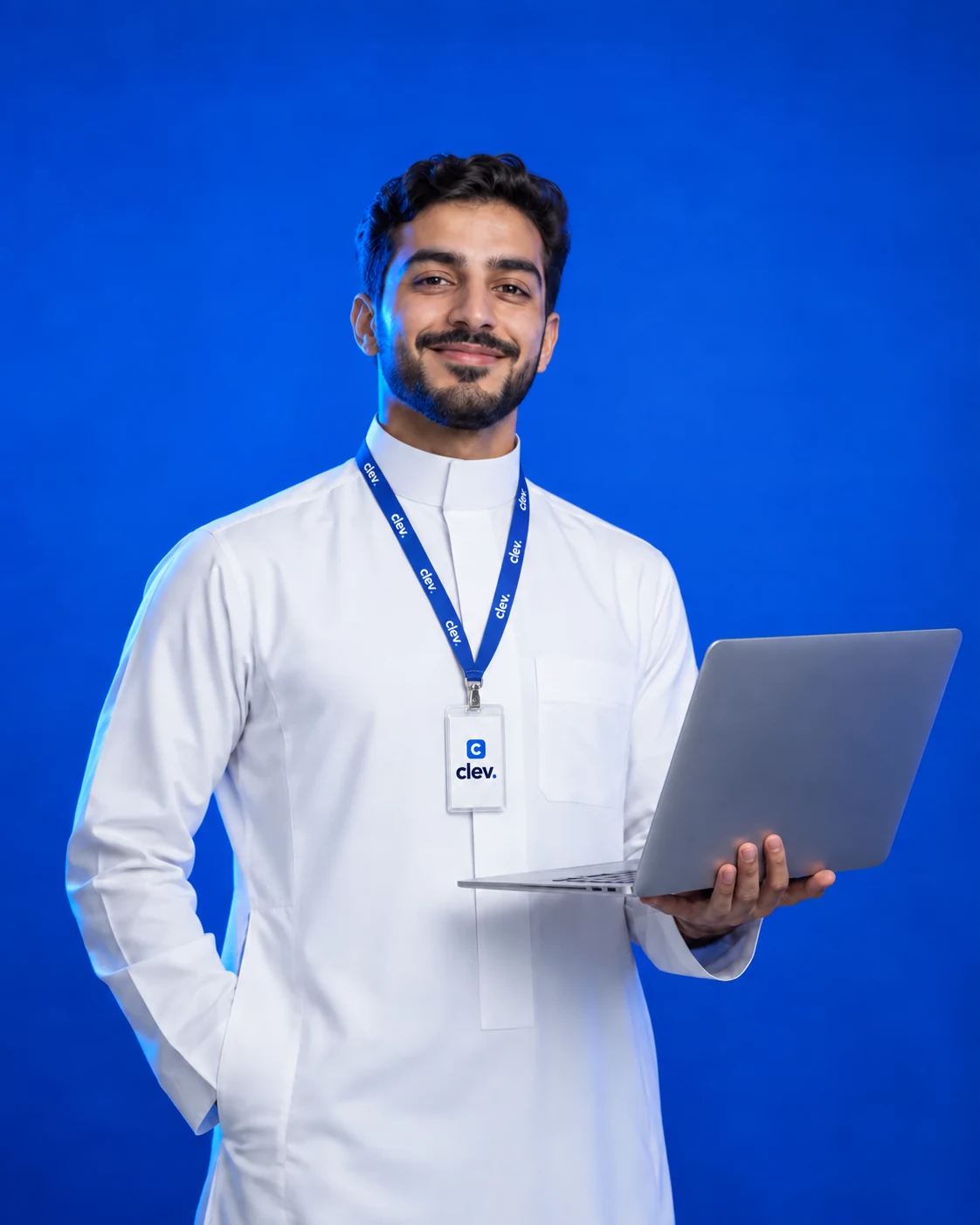 رائد أعمال سعودي يبتسم بثقة ويحمل حاسوبًا محمولًا